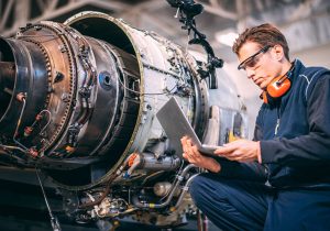 man using laptop next to equipment